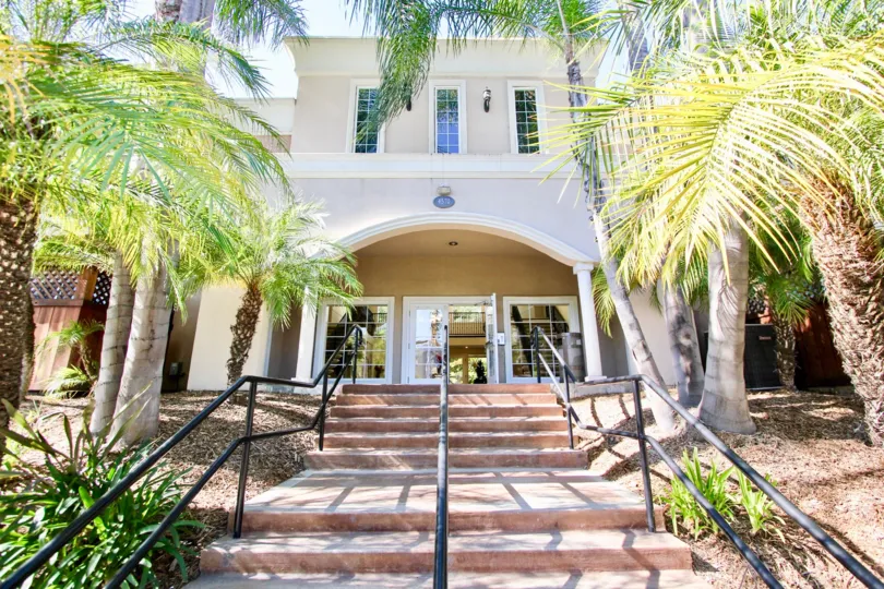 A large, white mansion with long windows located in carriage house
