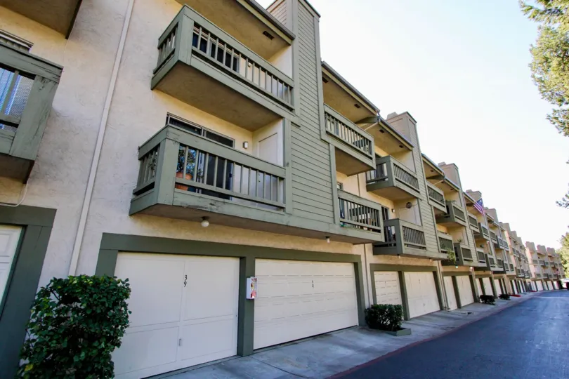 A long black driveway lined with housing & garages inside College Park Townhomes in College Area CA