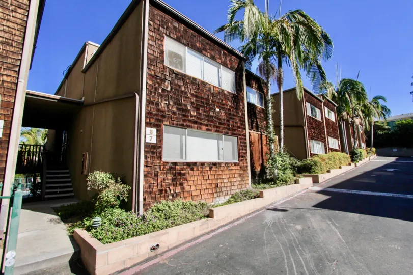 Driveway along side of two story residential buildings at Collwood Townhomes in College Area California