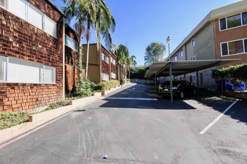 Driveway surrounded by parking area and residential buildings at Collwood Townhomes in College Area CA