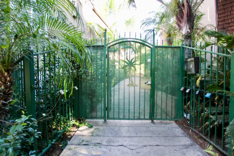 THE HOUSE IN THE COLLWOOD TOWNHOMES WITH THE STEEL GATE, PLANTS, TREES, POST BOX