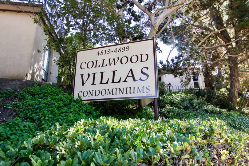 The Collwood Villas condominiums sign stands in the sun on a landscaped hillside in College Area, California.