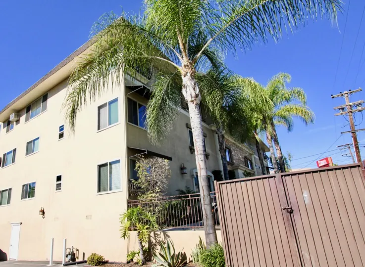 Four story residential building next to dumpster at Courtyard at College in College Area California