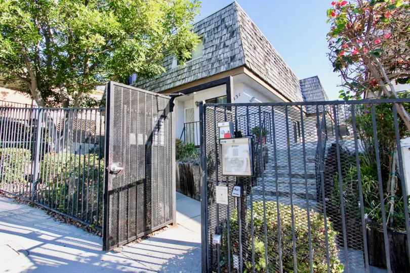 A Mediterranean Villa with a black fence & plants at College Area CA
