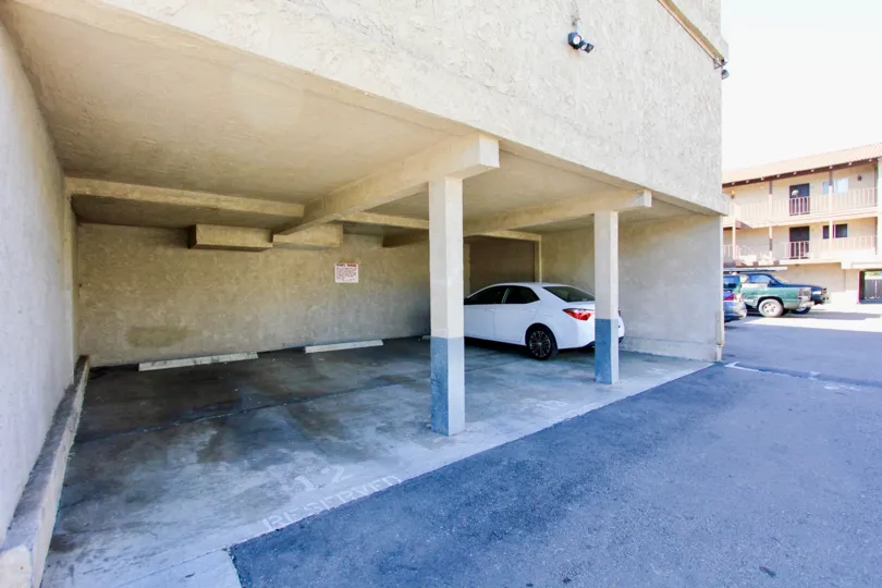 a pleasant day in the menlo ave condos with a building that has parking at its ground floor with awhite car parking