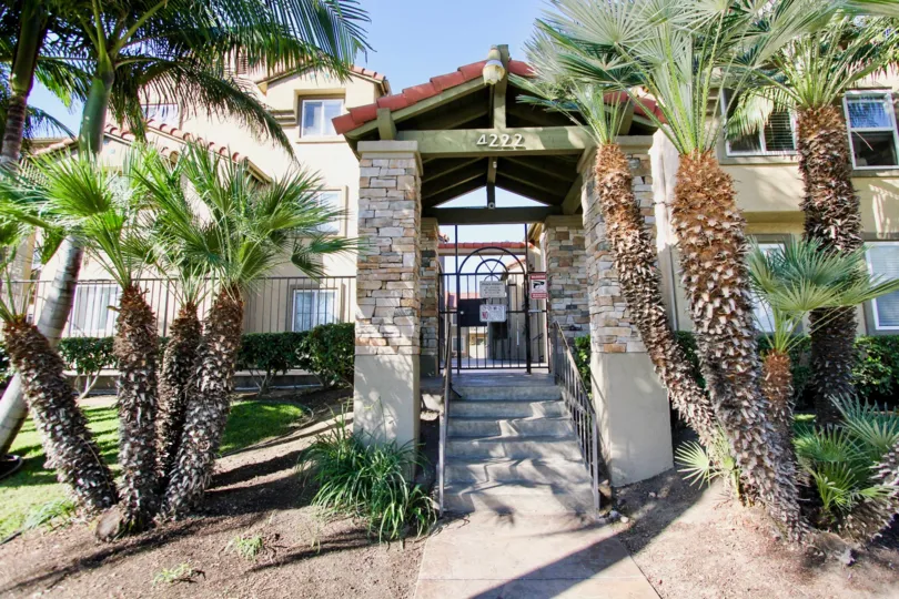 A front vie of a 4222 apartment complex with palm trees as decoration in the front in Menlo Village