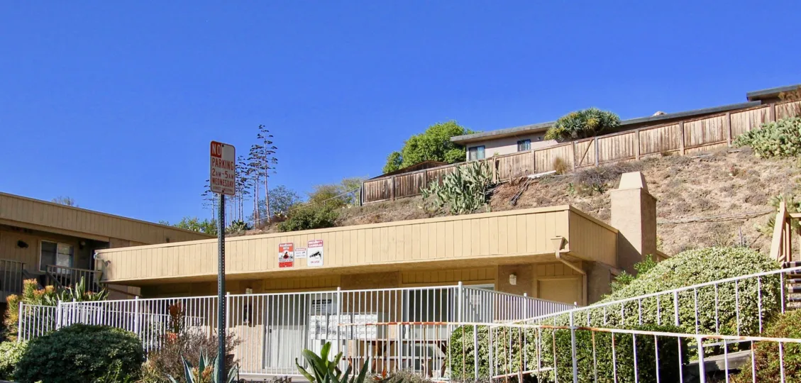 THE HOUSE IN THE MESA GREENS WITH THE PLANTS, NO PARKING BOARD, STEPS