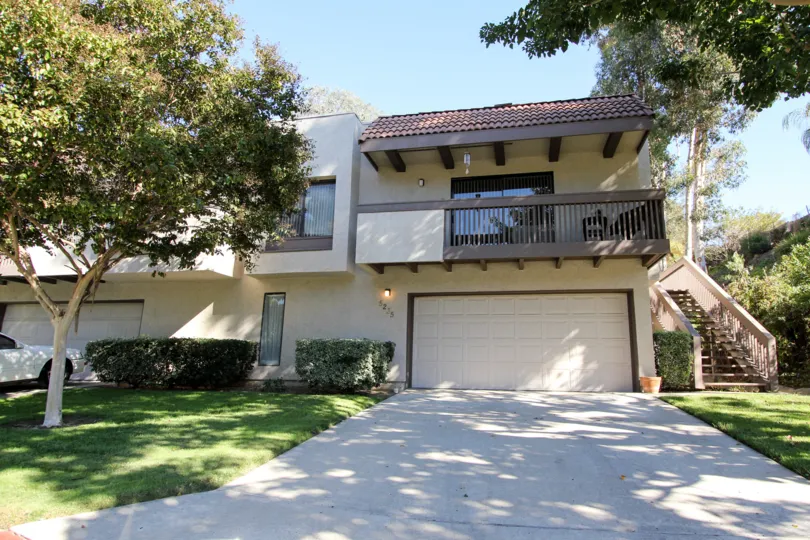 THE 6275 APARTMENT IN THE MONTEZUMA TOWNHOMES WITH THE TABLES, CAR PARKING, UPSTAIRS, PLANTS, TREES, GRASSES