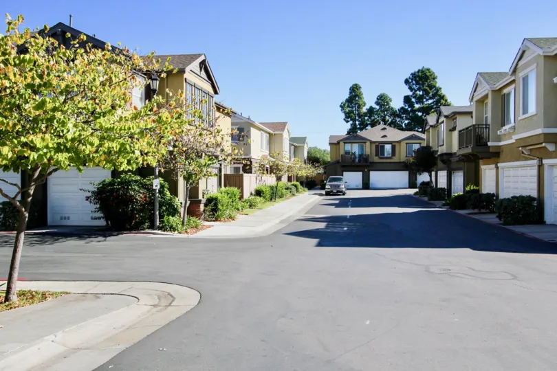 A paved driveway surrounded by housing with garages inside Orange Walk in College Area CA