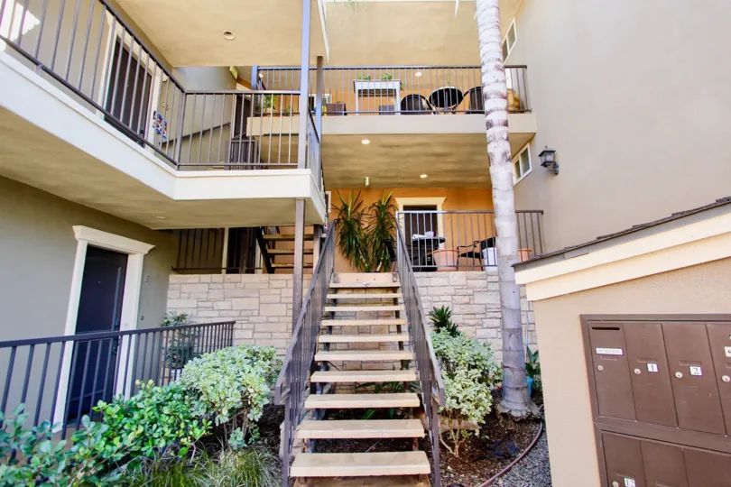 A sunny day in the area of Rivabella, stairs, condo, mailboxes, plants, table, door