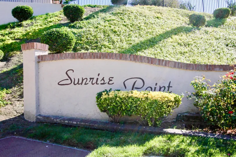 The Sunrise Point with name board at the entrance and lush green grass around