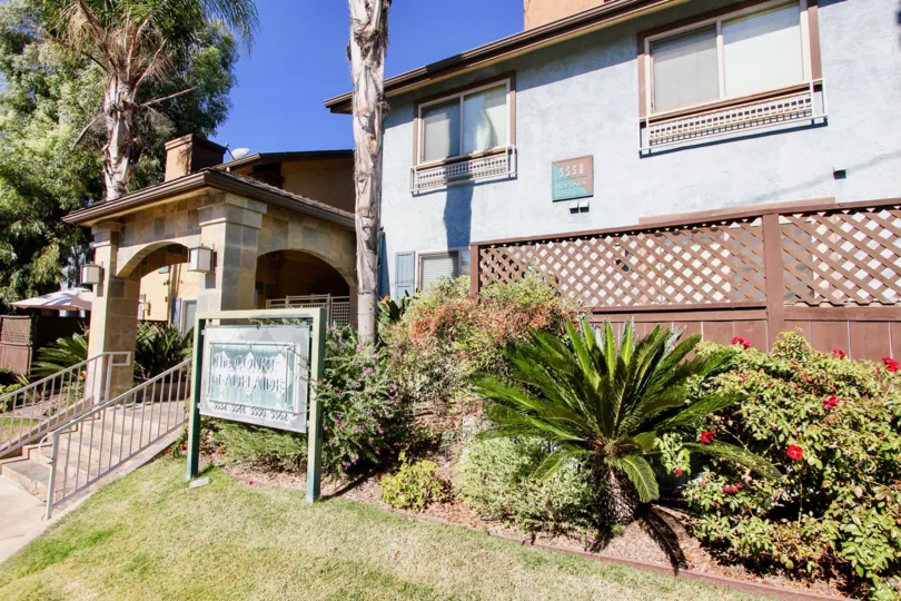 A Bright sunny day with lawn and trees with flowers in front of a House in The Court at Adelaide of College Area