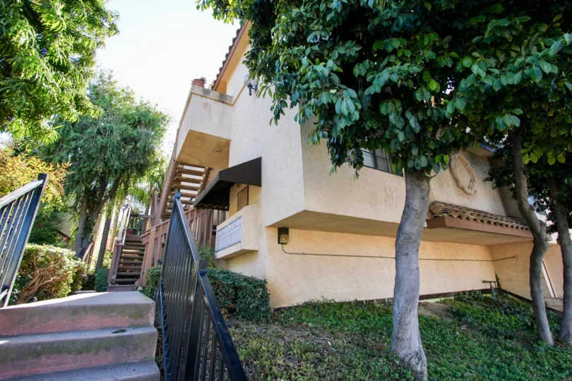 Stairway next to residential building surrounded by trees at Villa Estelle West in College Area California