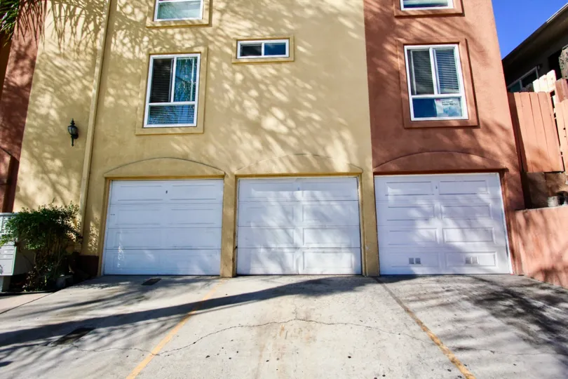 Driveway leading up to a residential building with attached garages at Villa Toscana in College Area California