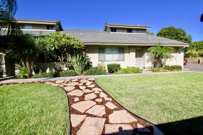 One story home with walkway and green yard at Wellington Townhomes in College Area California