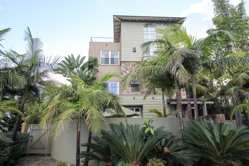 Three story residential building with palm trees at Bridgend Lanai in Coronado California