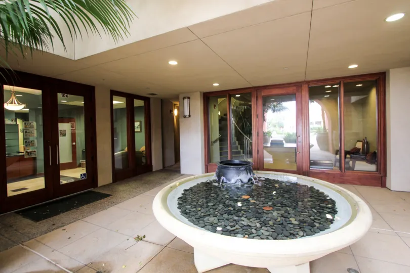 The courtyard in Coronado City Views, Coronado California with a fountain with stones inside.