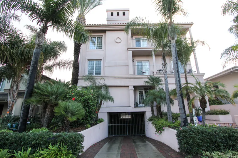 A front view of a apartment in Harborside court along with trees and plants
