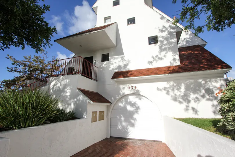 Outer view of the building in Island Village with street view of house and garden.