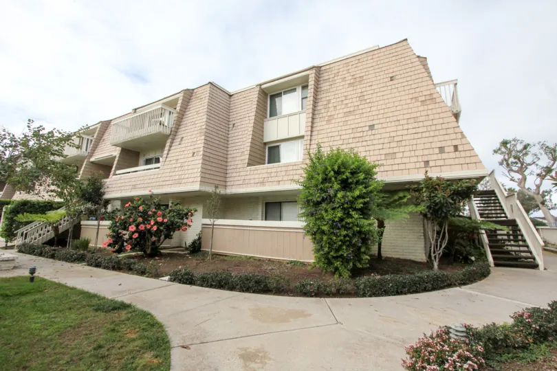A home in Montego Village with landscaping including flowers and sidewalk