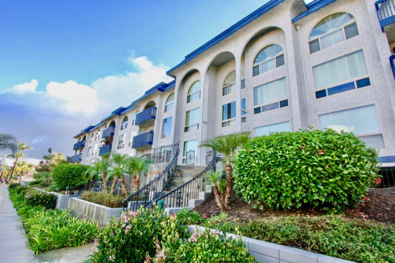 A sunny afternoon in the area of The Commodore bushes, condos, stairs