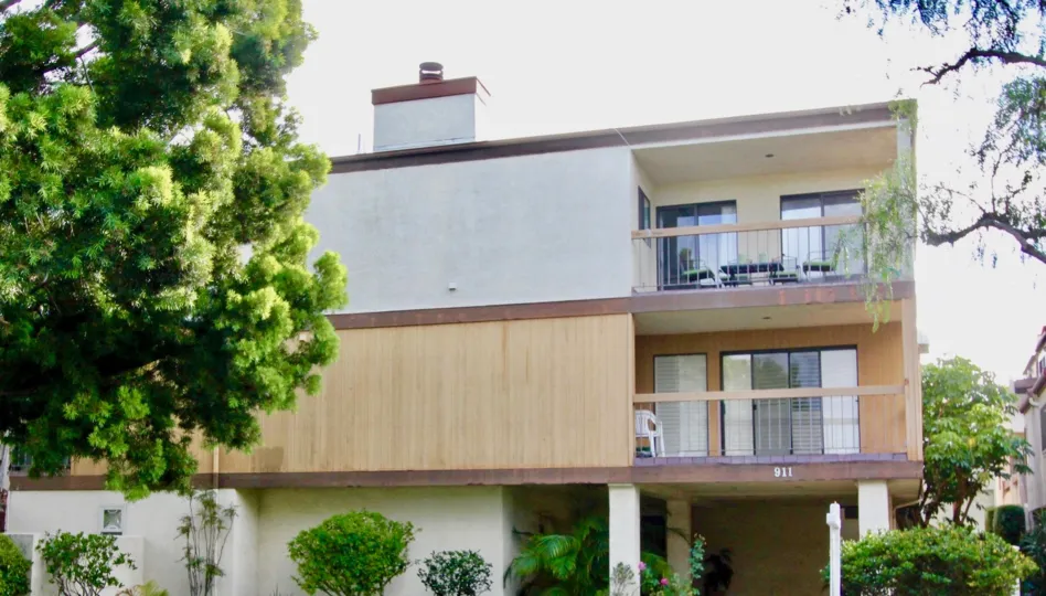A apartment in Villa Del Sur has a number 911 with trees and plants