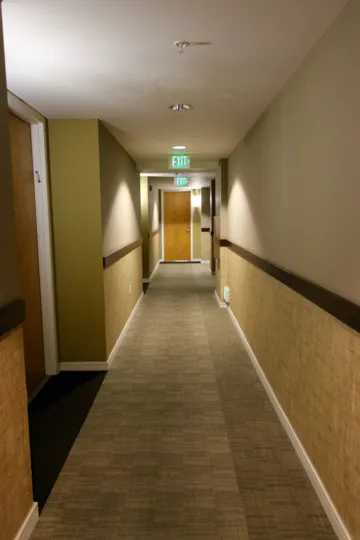 Main access hallway of 350 West Ash community with ceiling sprinklers and standard exits