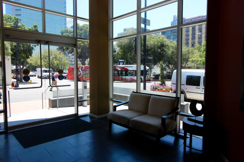 A view from the interior of the office building at 350 West Ash shows a city view through the sleek glass windows.