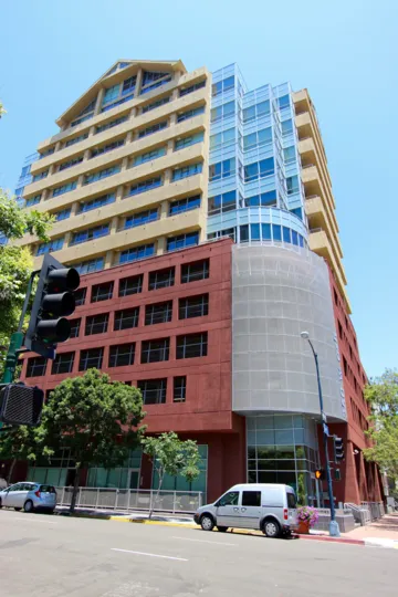 A stoplight next to a large building in downtown San Diego, California.