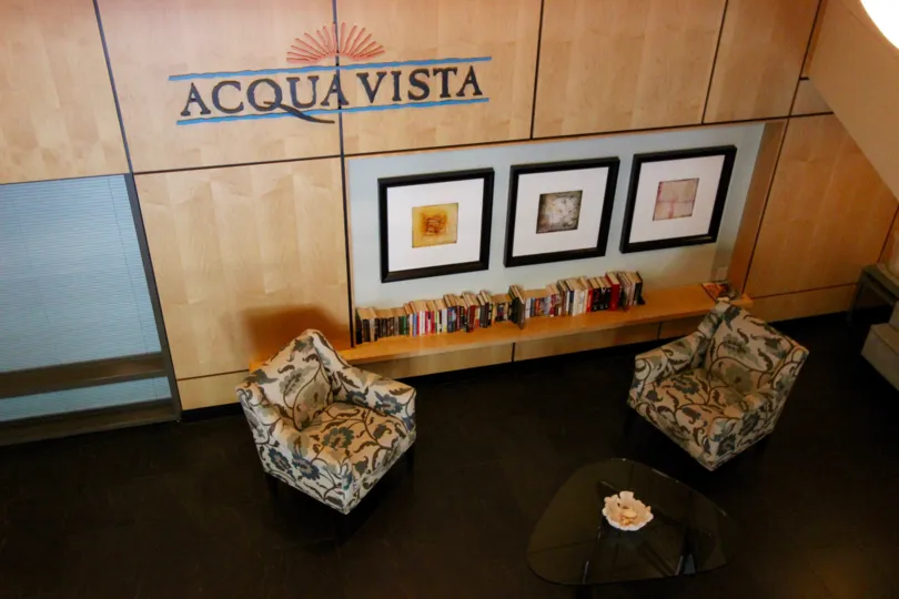 Two chairs and framed pictures under community sign at Acqua Vista in Downtown San Diego CA