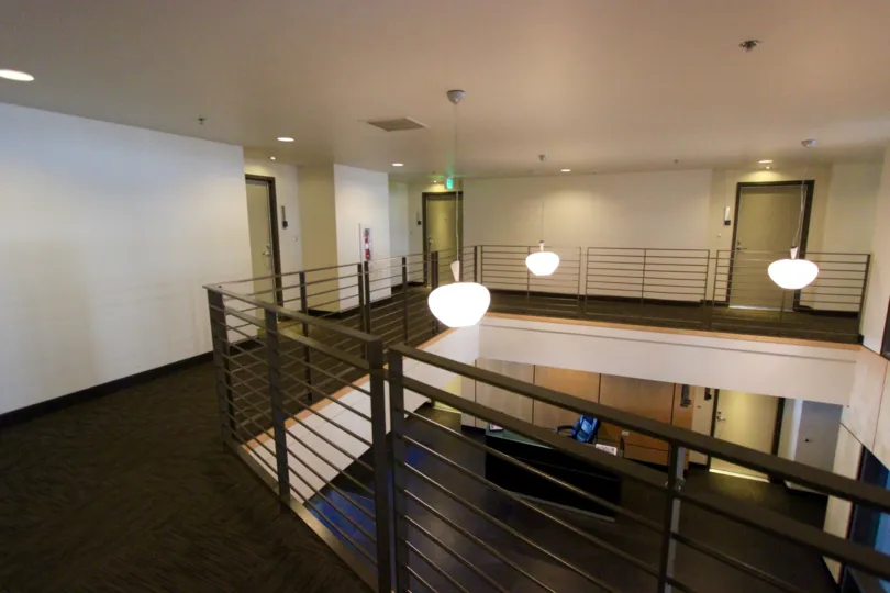 A lobby as viewed from an upstairs balcony complete with modern decorative lighting
