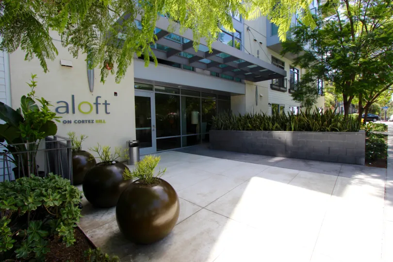 Sunny entryway surrounded by lush greenery at Aloft in Downtown San Diego, California.