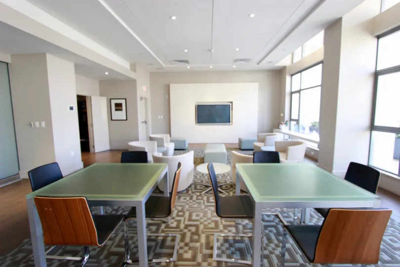 Welcoming common area with tables, chairs, and television in Alta.