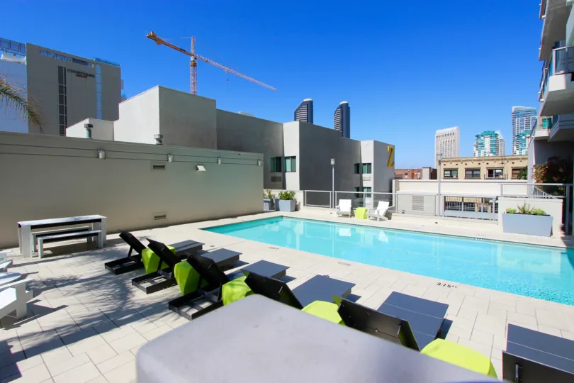 A sunny day poolside in the area of Alta, lawn chairs, rooftop, pool, picnic tables