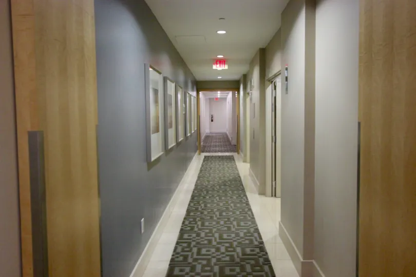 Hallway with track lighting lined with pictures in frames at Alta in Downtown San Diego CA