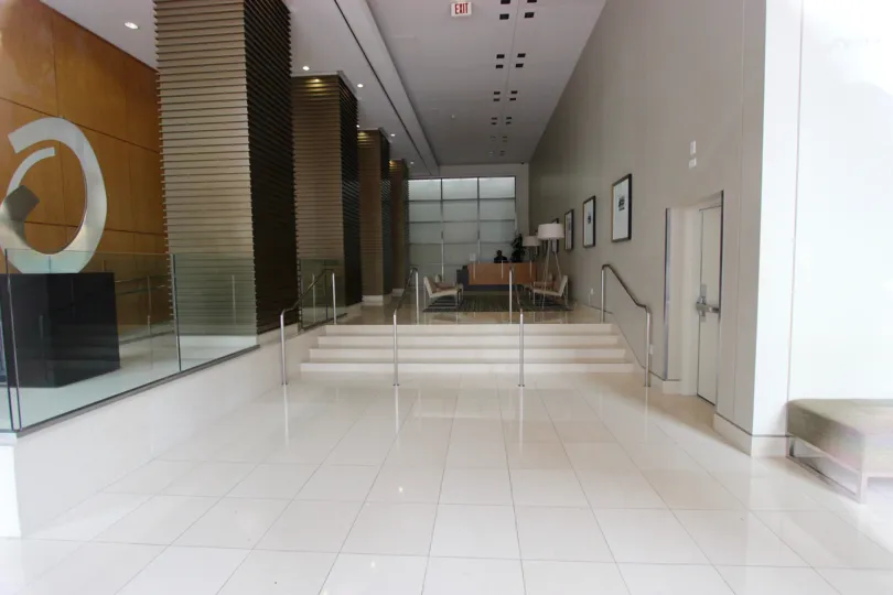 Inside Alta, with white floors, seating area with art on the walls and a circular sculpture for viewing