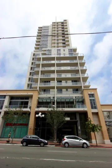 A white residential tower rises into the sky at Alto condos.
