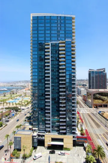 Tall condo high rise with blue glass windows at the Bayside in Down downtown San Diego CA