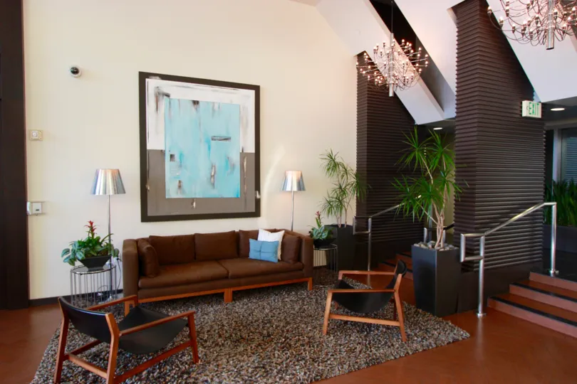 An interior view a community area in the Breeza building with retro furniture and framed modern painting.