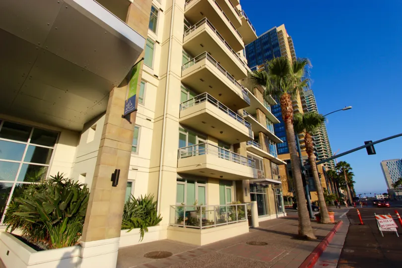 A view of the exterior of the Breeza highrise apartment building from the city street with residents' balconies.
