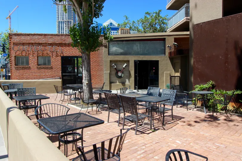 A brick dech with tables and chairs in the Brickyard community in downtown San Diego, CA