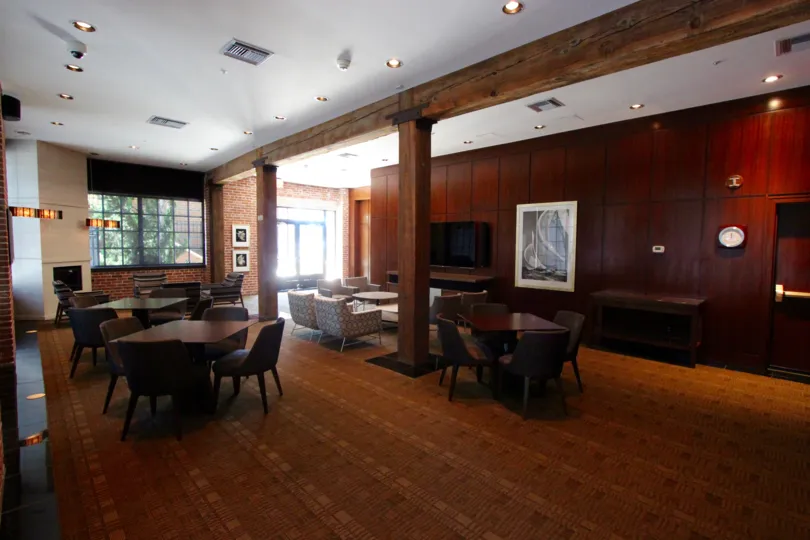 Tables with chairs inside a wood paneled room inside Cityfront Terrace in Downtown San Diego CA