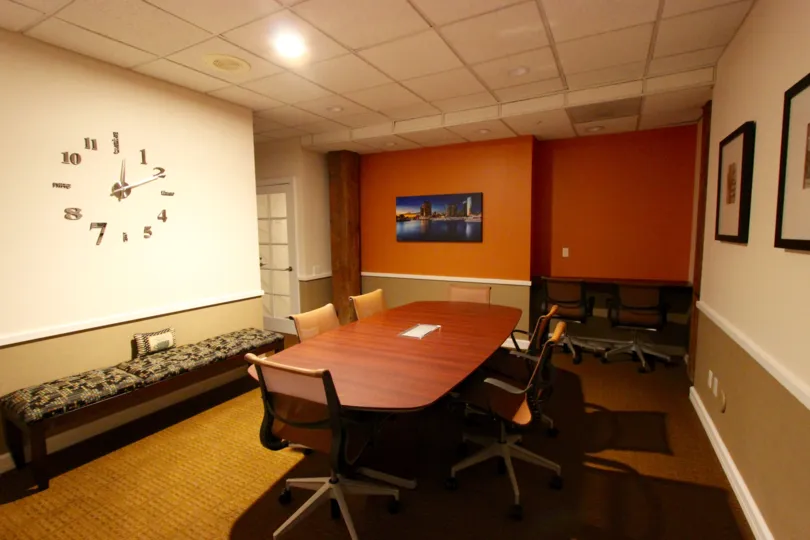 The well appointed conference room in the Cityfront Terrace with a conference table and rolling office chairs.