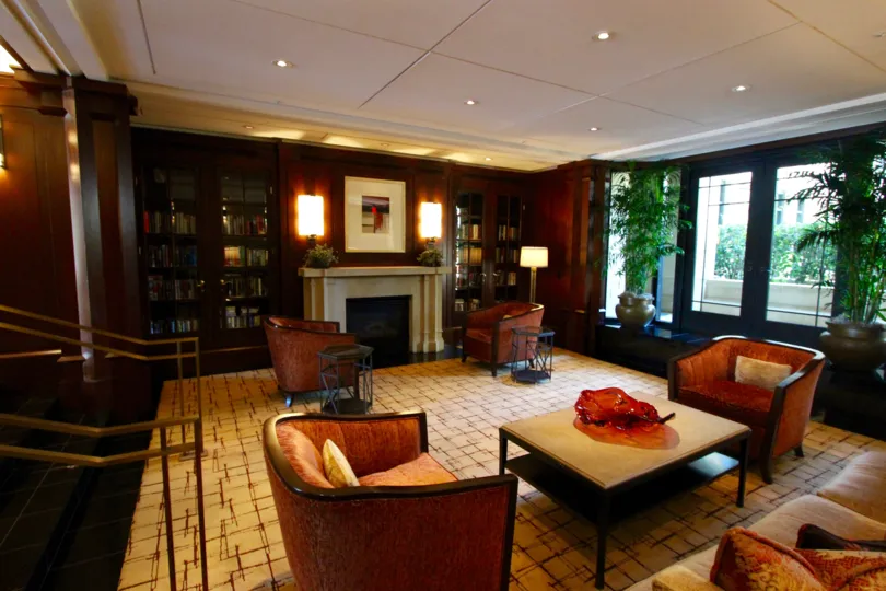 An interior view of conversation groups next to a fireplace and book shelves at the Cityfront Terrace building.