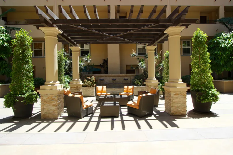 Orange and brown patio furniture sits under a pergola at Citywalk condos