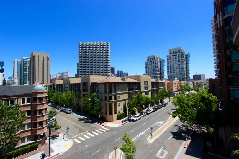 Elivated view across the street showing the Citywalk Condominium Downtown San Diego California with parked cars by sidewalks and lanscaped trees