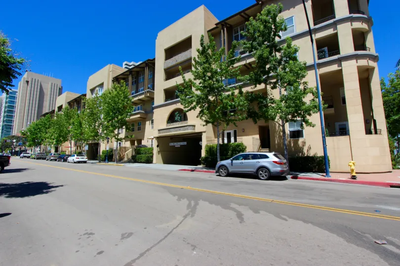 The exterior of a block of buildings along the street in the Citywalk community with shade trees.