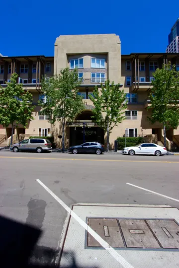 A sunny day in Citywalk neighborhood, view of a building and park cars on a street