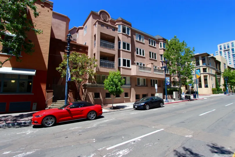 Cars parked outside of pink town homes in Columbia Place in Downtown San Diego CA