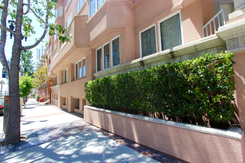 The outside of a peach building in the A blue building with the address of 822 San Juan Place community in Downtown San Diego in CA.